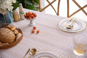 Close-up of French lace tablecloth featuring intricate hollow floral patterns and wavy edges