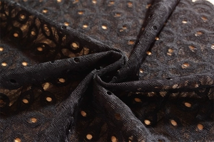 Detail of black floral lace table runner with intricate hollow embroidery and texture