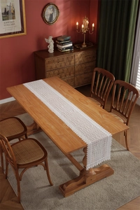 Close-up of white lace table runner with intricate hollow floral crochet patterns