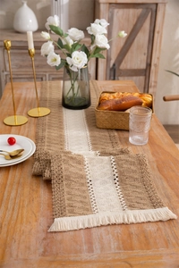 Detail of woven table runner with lace insert, tassels, and cotton linen texture