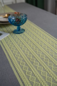 Detail of grey and yellow geometric jacquard table runner with bohemian woven patterns