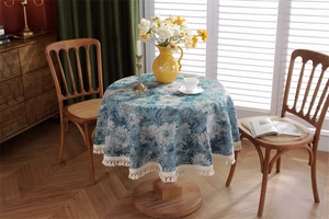 Detailed view of vintage blue jacquard tablecloth with daisy pattern and cream tassels