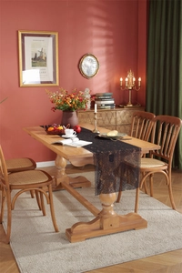 Detail of black lace table runner with rose floral patterns on a wooden dining table
