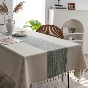Rectangular beige tablecloth with green geometric jacquard pattern and tassel edges