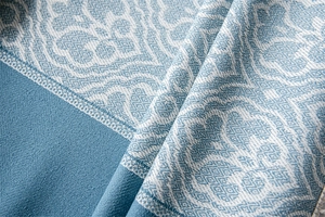 Macro shot of jacquard fabric with symmetrical patterns and fringe trim for tablecloths