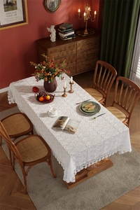 Detailed view of intricate white floral embroidery on French lace tablecloth fabric