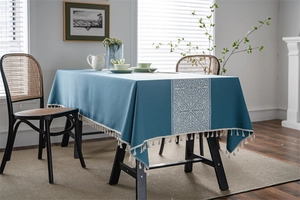 Detail of blue bohemian tablecloth showing ethnic floral print and cream tassel trim