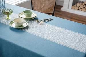 Close-up of blue jacquard tablecloth with white patterns and boho fringe detail