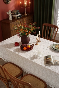 Close-up of white floral lace tablecloth with intricate embroidery and scalloped edges