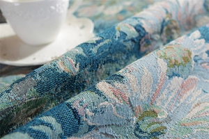 Close-up of vintage blue daisy jacquard fabric with detailed floral woven pattern