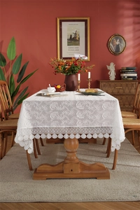 Close-up of white French lace tablecloth featuring 3D floral embroidery and scalloped edges