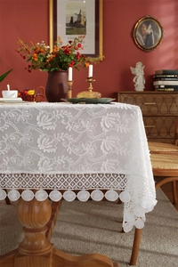 Close-up of French lace tablecloth with floral embroidery and geometric hollow lace edge
