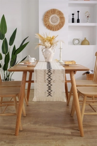 Détail d'un chemin de table en coton et lin avec motif en losange noir et franges