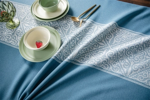 Detailed view of dark blue jacquard tablecloth with fringe and retro pattern textile texture