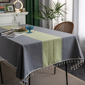 Gray jacquard tablecloth with green geometric pattern and white cotton tassels