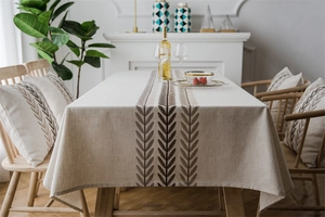 Dettaglio del runner da tavola in lino impermeabile con motivi di foglie e fiori beige