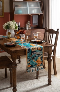 Détail d'un chemin de table jacquard tropical avec motifs de feuilles et glands bleus