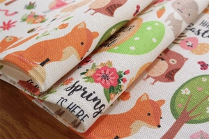 Close-up of Easter table runner with colorful animal prints on linen textured fabric