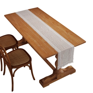 Elegant white lace table runner with hollow floral embroidery on a vintage wooden table