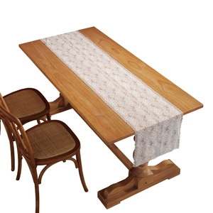 White French lace table runner with intricate rose floral patterns on a wooden table