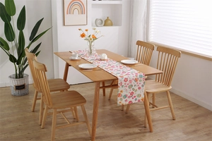 Detailed view of Easter table runner with colorful eggs and flowers on a wooden table