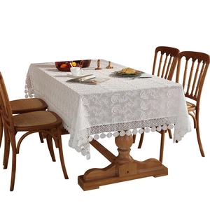 White French lace tablecloth with floral embroidery and tassel edge on wooden table