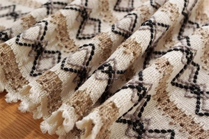 Détail du chemin de table tissé en coton et lin avec glands et motifs géométriques