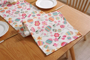 Detailed close-up of thick cotton Easter table runner with colorful eggs and floral print