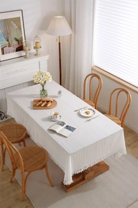 Detailed view of intricate white lace tablecloth with hollow embroidery and scalloped edges
