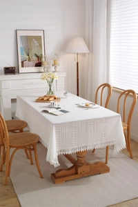 Detail of white cotton lace tablecloth with hollow embroidery and wavy fringe edges