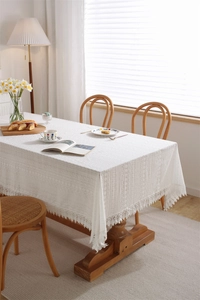 Detailed view of white cotton lace tablecloth with hollow embroidery and wavy edge