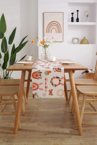 Detail of Easter table runner featuring cartoon rabbits and rainbows on wood table