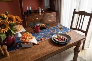 Détail d'un chemin de table vintage en jacquard tropical avec tissu bleu et franges