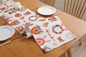 Detail view of Easter table runner featuring bunnies and eggs on a wooden dining table