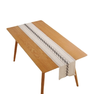 Chemin de table en coton et lin bohème avec broderie losange noire et détails à glands