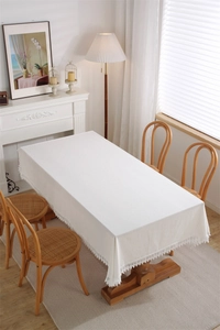 Close-up of white cotton lace tablecloth showing detailed crochet embroidery and textures
