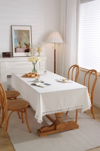 Detailed close-up of cream white lace tablecloth edge with intricate floral embroidery