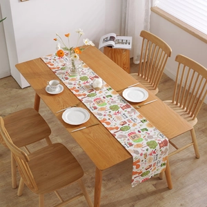 Modern Easter table runner with bunny and floral print on a light wooden dining table