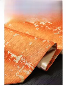 Detailed macro shot of luxury orange jacquard table runner with gold floral embroidery