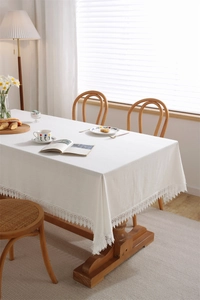 Detailed view of white cotton lace trim and intricate embroidery on a vintage tablecloth