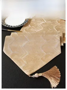 Detailed view of jacquard table runner with champagne chevron pattern and silky tassel