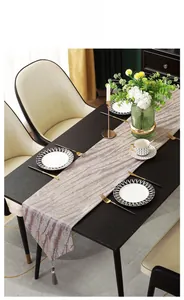 Macro detail of modern luxury jacquard table runner with textured stripes and grey tassel