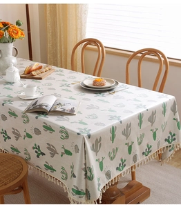 Dettaglio della tovaglia impermeabile con stampa cactus e bordi decorativi con nappe