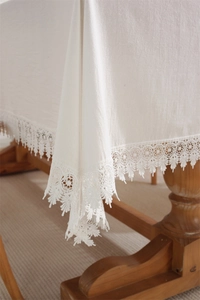 Close-up of white cotton lace tablecloth with intricate floral embroidery details