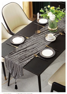 Detail of luxury polyester jacquard table runner with black tassels and wave pattern