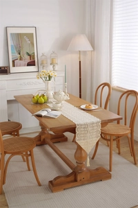 Close-up of cream crochet lace table runner with hollow geometric patterns and tassels