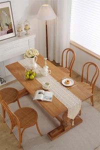 Detailed view of beige crochet table runner with lace fringe on a rustic wooden table
