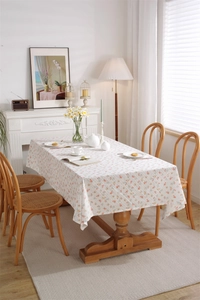 Detail of French floral print cotton tablecloth with pink and orange flowers on white