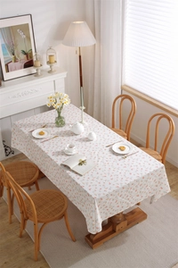 Detailed texture of French cotton floral tablecloth with soft fringe edges and drape