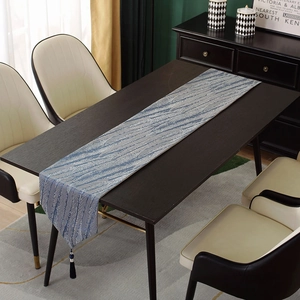 Close-up of modern jacquard table runner texture with blue hanging tassel ornament